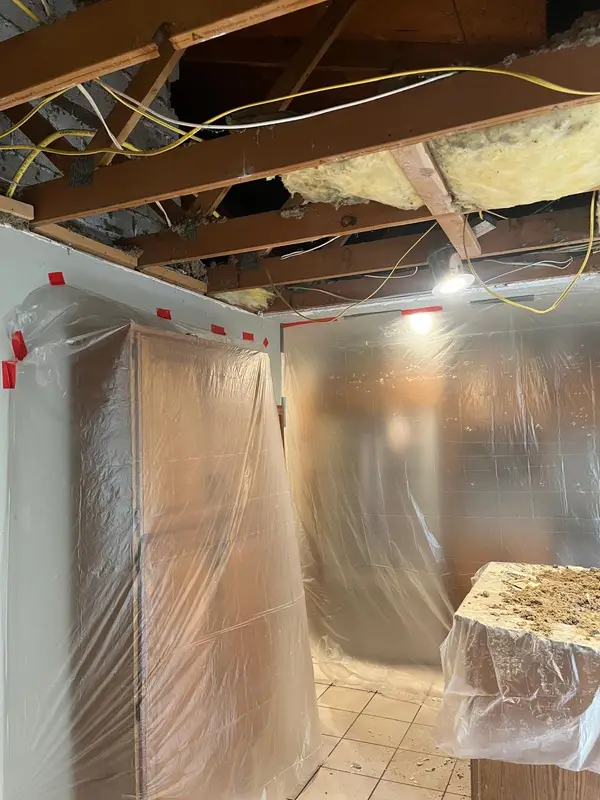Kitchen covered in plastic while the open ceiling is repaired